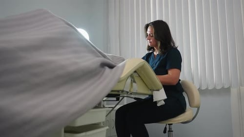 Woman Preparing Examination Room for Patient
