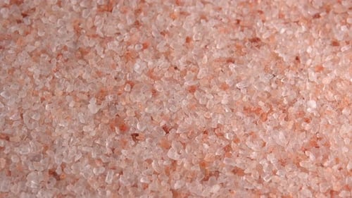 Pink himalayan salt or rock salt rotating close up background side light. Trace minerals salt used