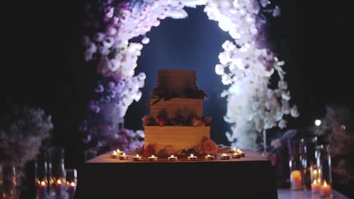 Romantic Wedding Cake with Candlelight and Floral Arch