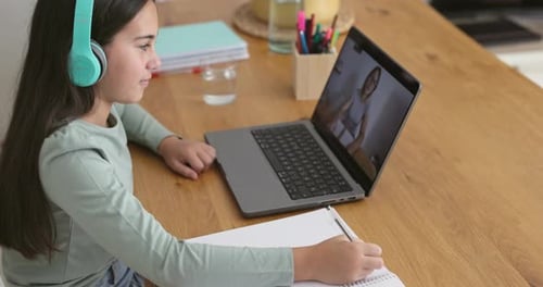 Female kid using laptop for tutoring lessons at home - Back to school
