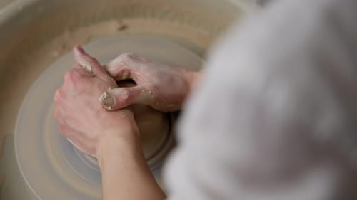Craftsperson Shaping Clay on a Pottery Wheel