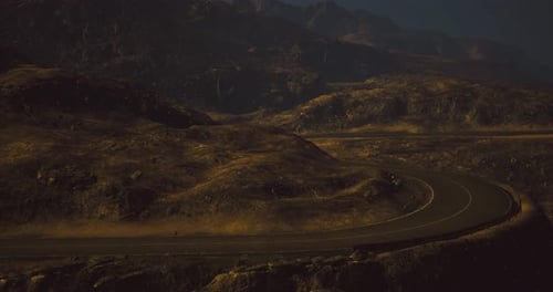 Winding Road Through Desolate Mountains at Twilight Under a Starry Sky