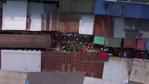 Drone view of Maeklong Market and railway tracks with local vendors, Thailand