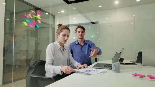 Office Workers Analyzing Statistics Papers in Startup Office