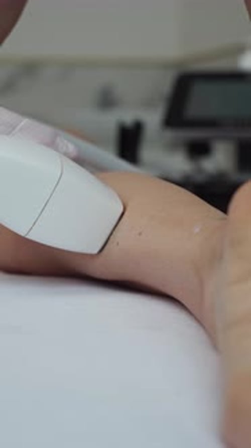 Leg Depilation Session in a Beauty Clinic a Cosmetologist Waxing a Woman Leg