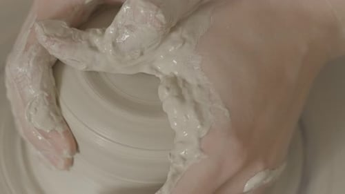 un gros plan d'une femme travaillant sur le tour de poterie