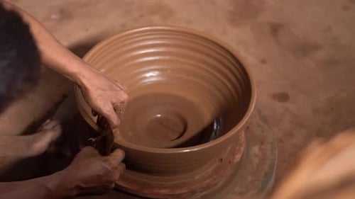Person Making Clay Pot on Pottery Wheel
