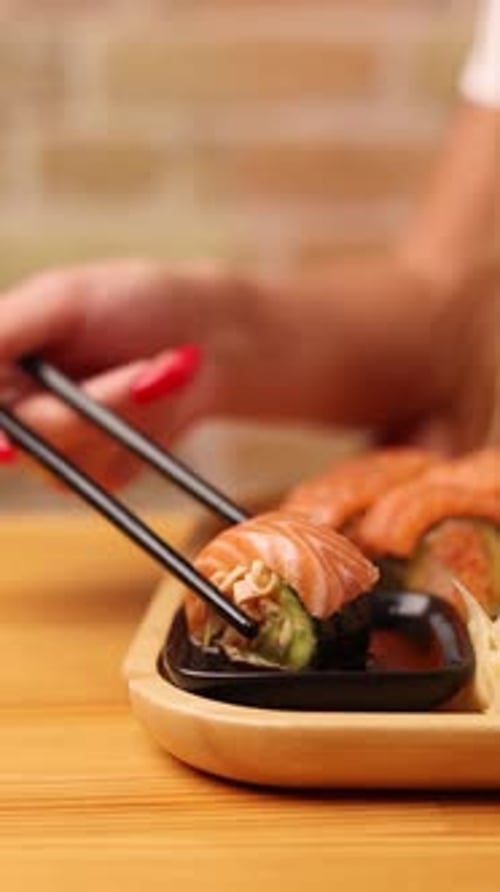 Close-up of Hand Picking Up Sushi with Chopsticks