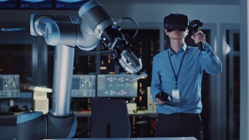 Man in VR headset controls robotic arm