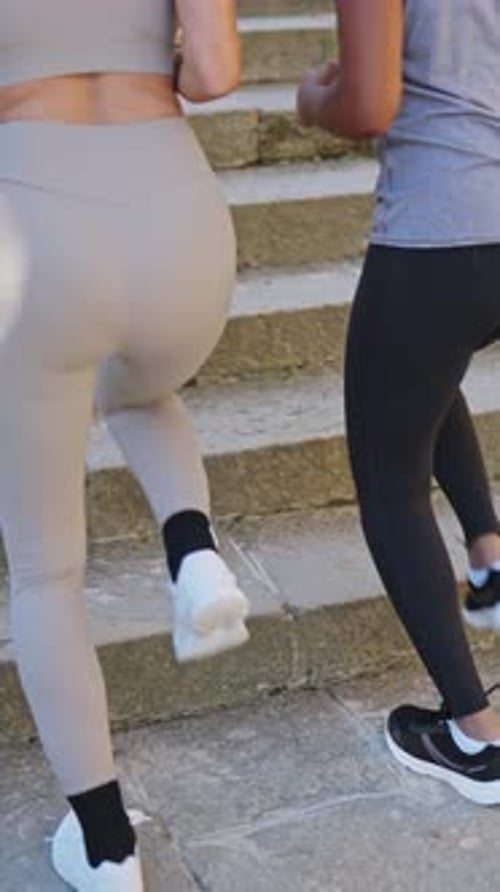 Athletic Women Ascend Steps in City Setting