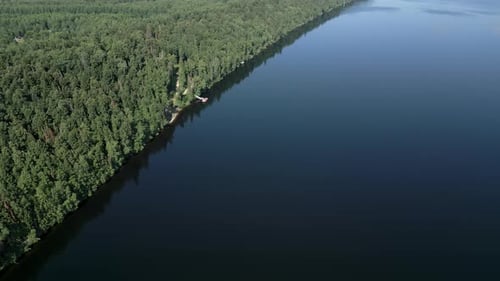 This Aerial Image Shows a Serene Forest and Calm Lake Highlighting the Landscapes Beauty Clip