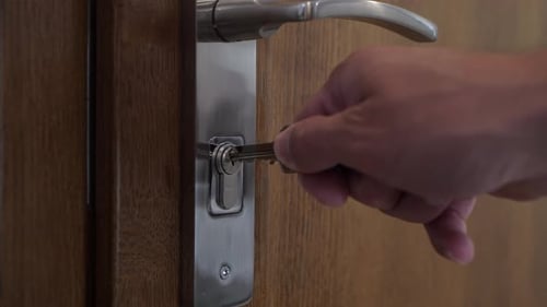 Opening a locked wooden interior door. Turning the key in the lock.