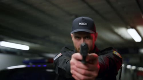 Front View Policeman Shooting with Gun. Male Cop Aiming Pistol at Camera