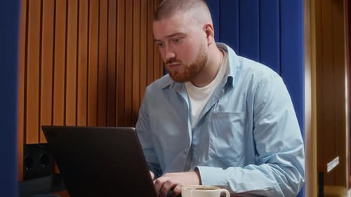 Male Employee Doing Report on Laptop in Modern Coworking Space