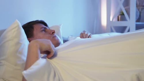 Insomnie nocturne Trouble du sommeil Homme agacé au lit