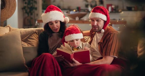 Family Reading Christmas Book on Couch Together