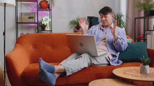 Young Adult Video Chatting on Laptop at Home