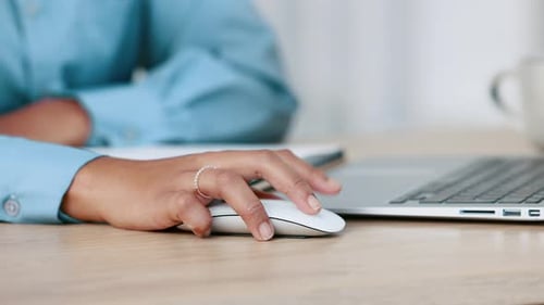 Business woman hands clicking a computer mouse while working on an office table at work