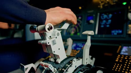 Close-up of a pilot's hand pressing the throttle in the cockpit of a jet plane reducing engine power