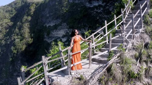 Woman admiring Diamond Beach in Nusa Penida island Indonesia from above the cliffside staircase, Aer