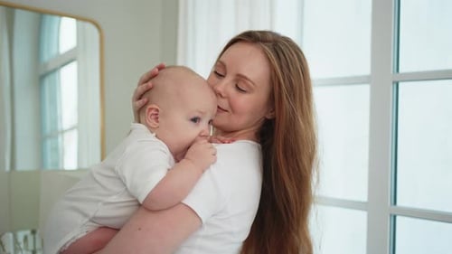 Loving Mother Holding her Infant Child at Home