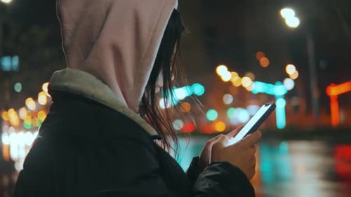 City After the Rain and a Girl Standing in the Rain with a Phone