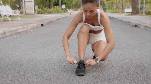 Young fitness woman in sportswear jogging in city park