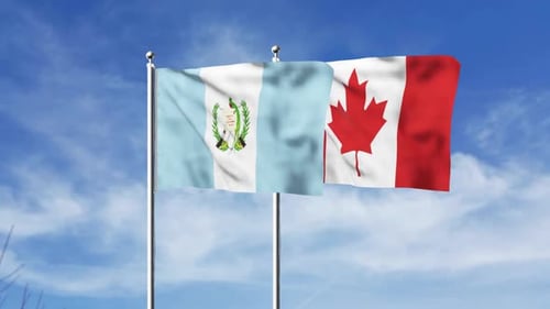 Waving Flags of Guatemala and Canada Against Blue Sky
