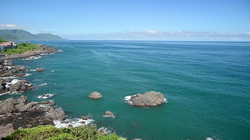 Blue sea and blue sky with changing white clouds. Small islands and rocks.