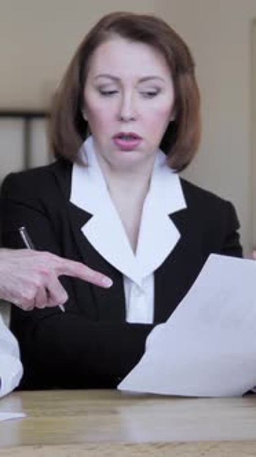 Businesswoman Reviewing Documents with Colleague in the Workplace