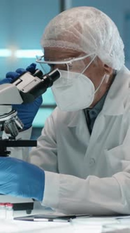 Scientist Analyzing Sample Under Microscope in Laboratory