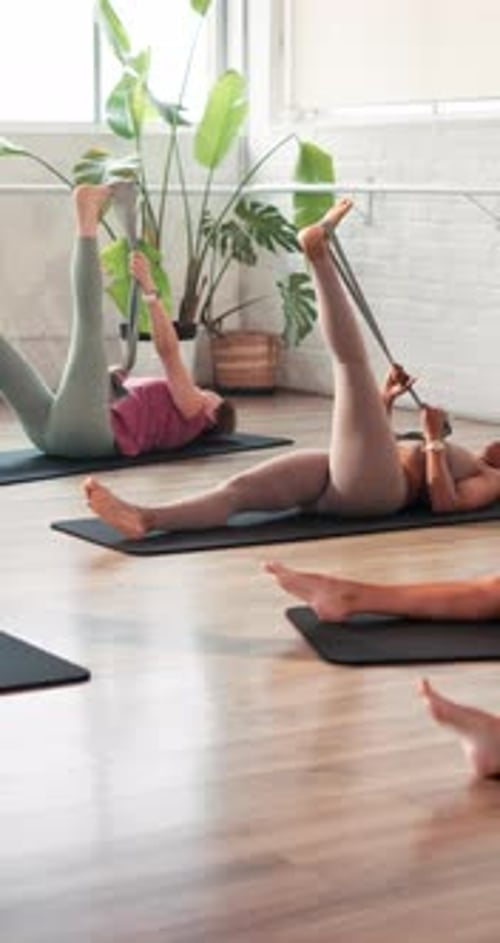 Pilates class, fitness and woman with resistance band in studio, stretching legs or core training