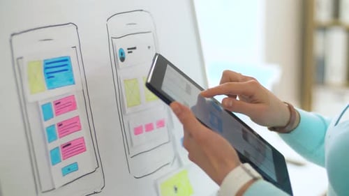 Woman Designs Mobile App Interface on Tablet