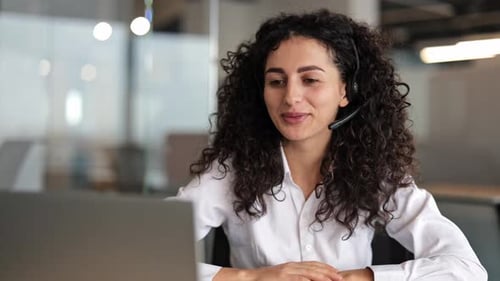 Young Businesswoman in Headset Video Conferencing in Modern Office