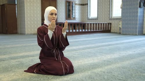 Woman Kneels Praying Inside Decorated Building