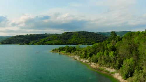 4k aerial drone shot over shoreline and island outcropping of a lake in Europe.