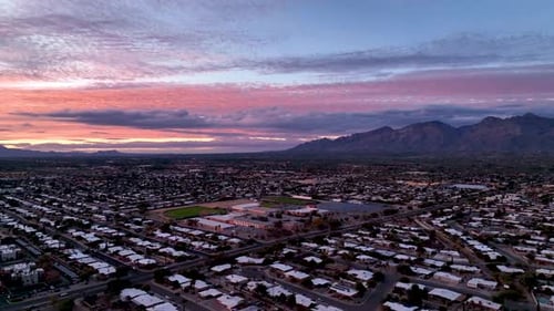 Cinematic slowly panning drone shot during sunset of Tuscon Arizona, starting on the mountains