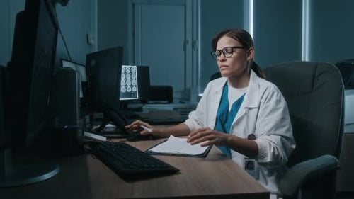 Female Doctor Working Late at Computer in Office