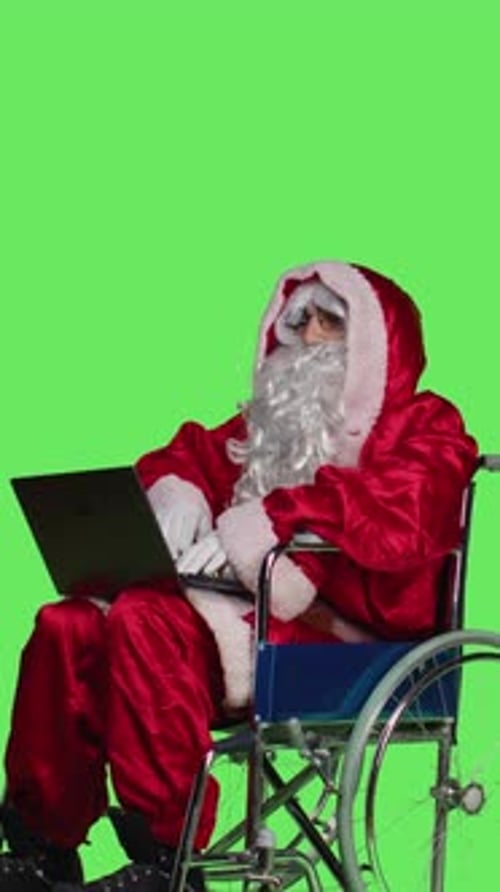 Vertical Video Side View of Saint Nick with Disability Using Laptop