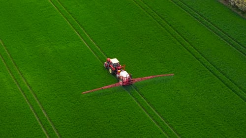 Farming Tractor Spraying Field During Seasonal Treatment Agricultural Vehicle Applying Spraying on