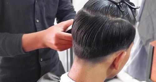 Barber Giving Man's Haircut with Electric Trimmer