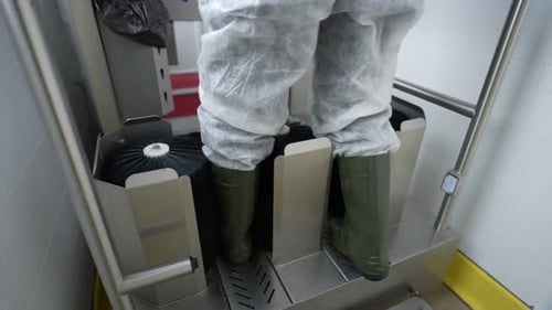 Worker Cleans Boots on Industrial Boot Cleaning Machine