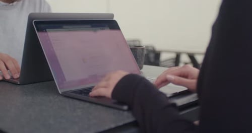 Teamkollegen arbeiten draußen mit dem Laptop und chatten