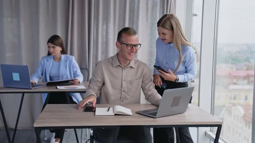 Des collègues qui communiquent joyeusement au travail.