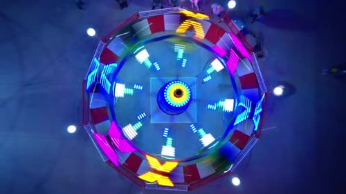Aerial View of a Spinning, Colorful Carnival Ride at Night