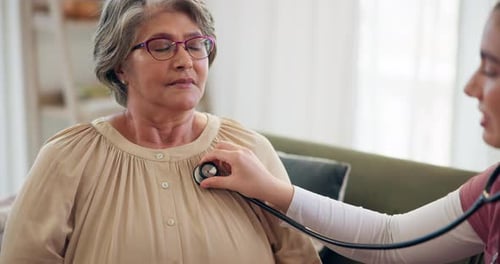 Doctor Checking Senior Woman with Stethoscope at Home