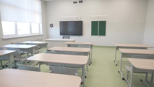 Empty Classroom with Desks and Television Screen