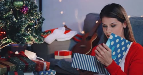 Woman Opening Christmas Gift with Holiday Cheer