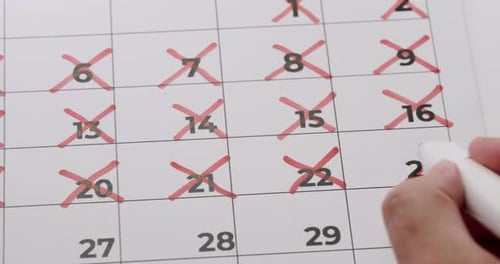 Marking Dates on Calendar with Red Cross for Schedule Planning