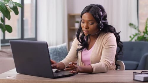 African american woman working remotely from home office on laptop computer